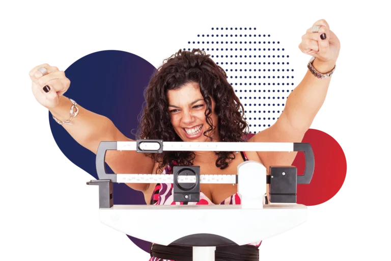 A smiling woman celebrating with both arms raised as she stands on a medical scale